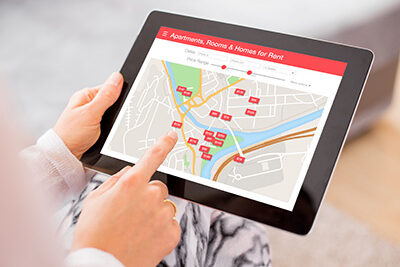 Hand touching tablet device in search of apartments for rent